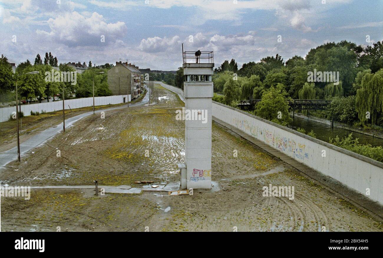 Berlin-Bezirk / DDR / 1990 Kreuzberg / Treptow: Die Wachtürme an der Berliner Mauer sind bereits verlassen, aber das Mauersystem ist noch immer deutlich sichtbar. Links der Zaun in Ost-Berlin, der Patrouillenweg für die Soldaten, der Hundelauf, der Wachturm mit Suchscheinwerfer, rechts die eigentliche Mauer nach Kreuzberg. // Grenze / Geschichte / Kommunismus [automatisierte Übersetzung] Stockfoto