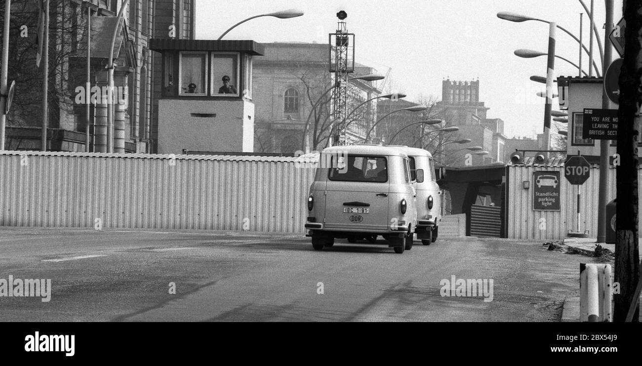 Berlin-Bezirk / Mitte /Tiergarten / 3 / 1986 Grenzübergang Invalidenstraße, zwei DDR-Busse fahren zurück nach Ost-Berlin. Sie transportieren DDR-Beschäftigte, die Pässe in West-Berlin ausstellen, zu Besuchen in Ost-Berlin. Hinter dem schmalen Durchgang durch die Mauer befindet sich auf der linken Seite das Regierungspital, das heute das Bundesministerium für Wirtschaft ist. // DDR / Sozialismus / // Vereinigung / Grenze / Todesstreifen / Bezirke / DDR // DDR [automatisierte Übersetzung] Stockfoto
