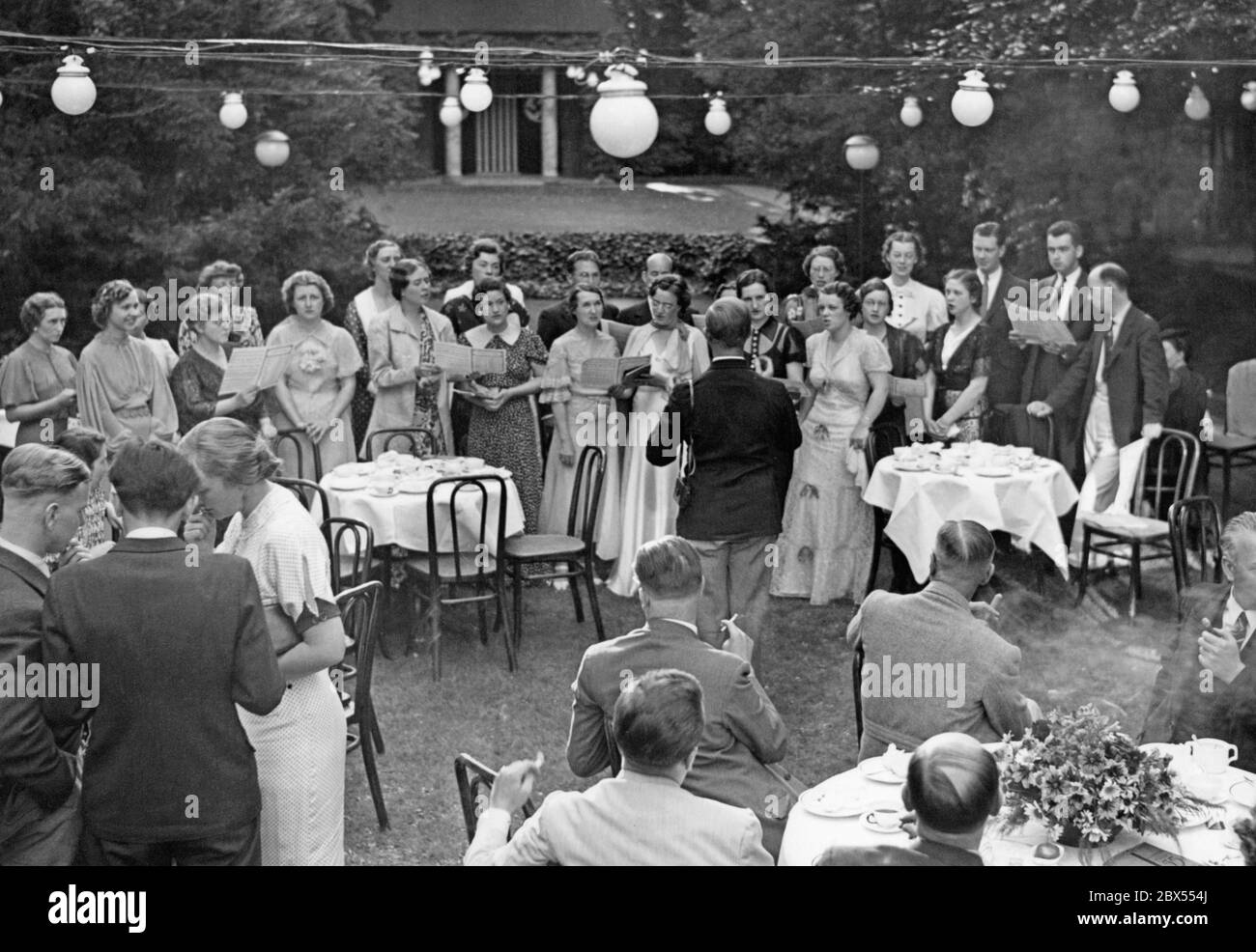 Die amerikanischen Musikstudenten singen im Garten unter der Leitung von Professor Tresskell von der Columbia University. Zu Ehren der amerikanischen Musikstudenten der Columbia University New York fand ein Empfang in der Carl Schurz Association in der Victoriastraße 7 statt. Stockfoto