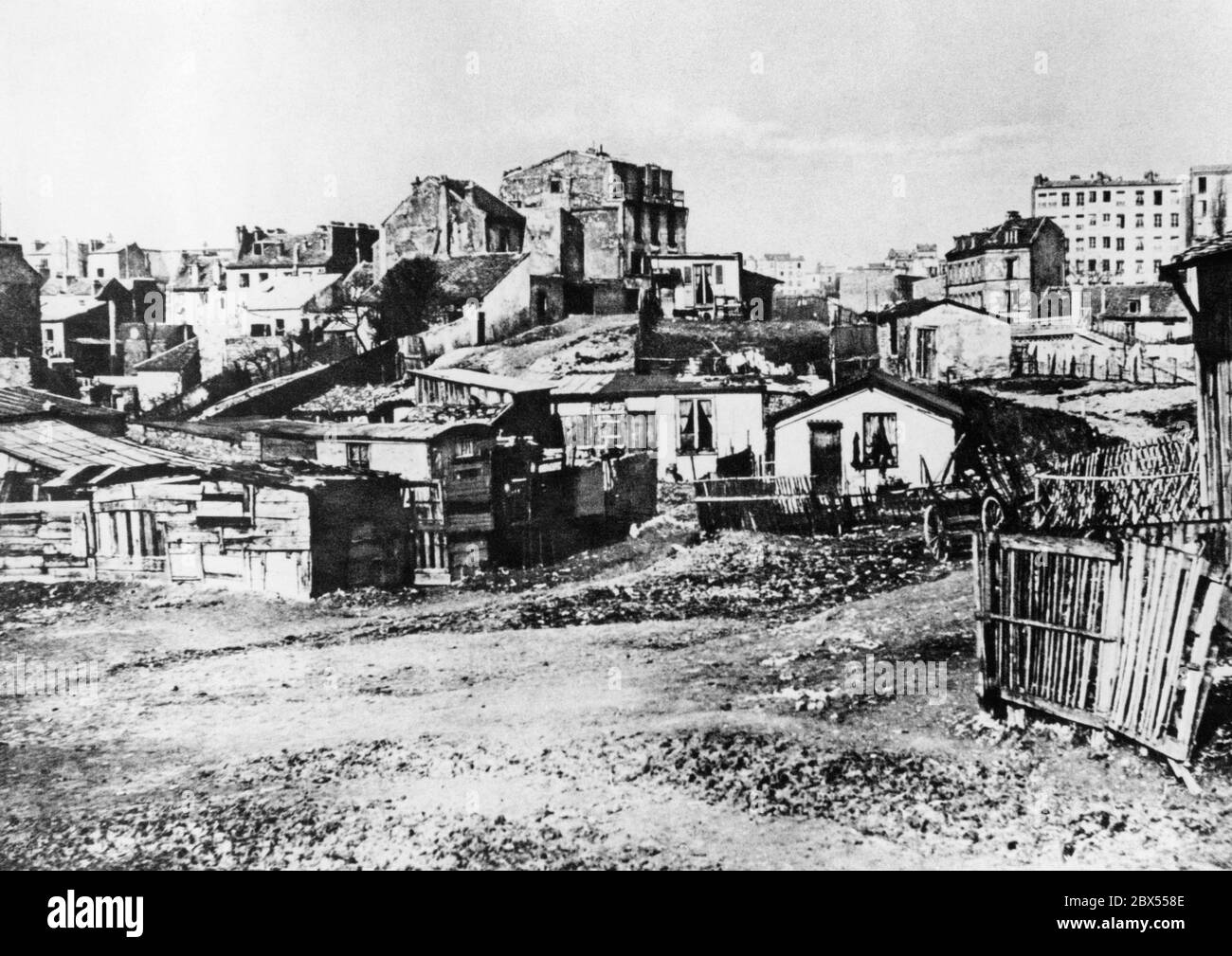 Temporäre Unterkunft für Arbeiter in der Rue Champlin, im Viertel Pere Lachaise, im 20. Arrondissement von Paris. Diese Arbeiterviertel waren hauptsächlich von ungelernten Arbeitern bewohnt, die vom Land in die Industriegebiete kamen, um Arbeitsplätze und ein besseres Einkommen zu finden. Die Häuser bestehen aus einzelnen Holzlatten, haben Löcher und sind sehr klein. Stockfoto