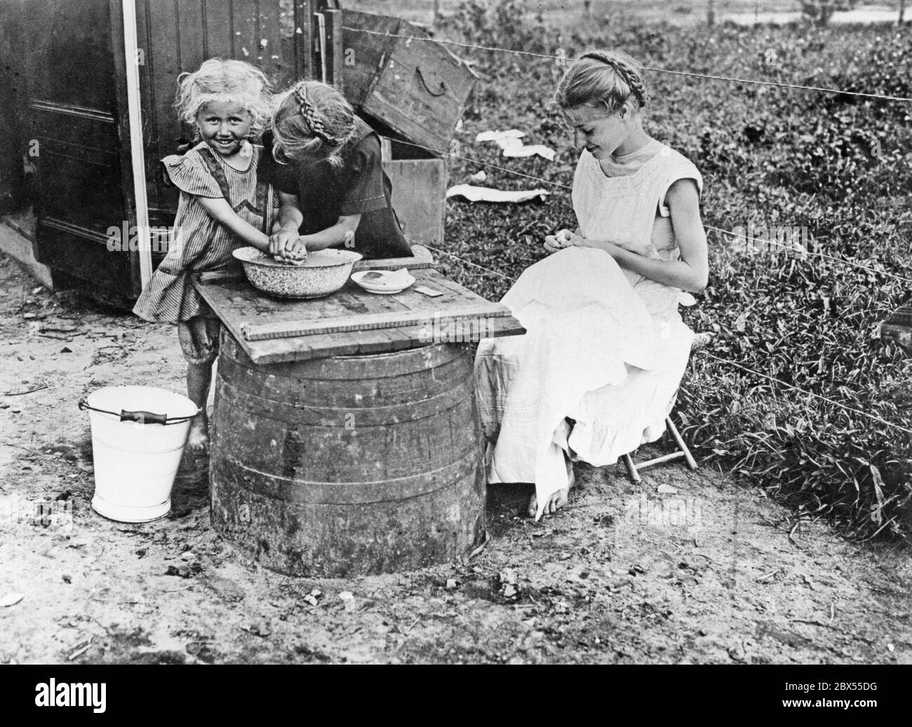 Eine Mutter mit ihren Töchtern in einer Gartenkolonie, die nach den Vorstellungen des Erfinders Schrebers ab der Jahrhundertwende in großer Zahl aufwuchs und für die Erholung der städtischen Bevölkerung bestimmt war. Stockfoto