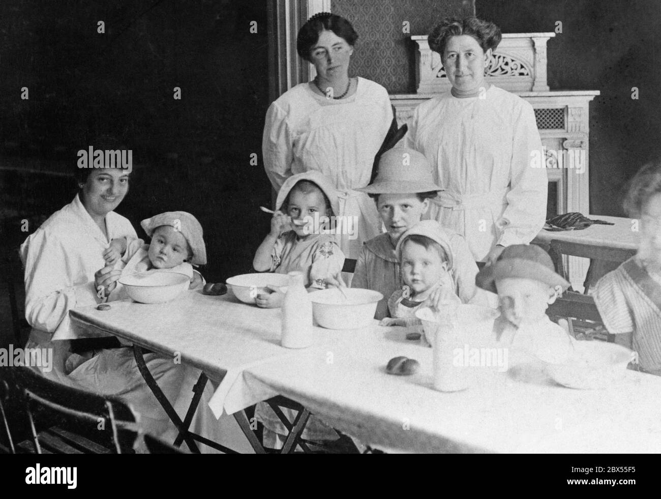 Die Damen der hohen Gesellschaft geben den Kindern der Soldaten zu Beginn des Ersten Weltkrieges Nahrung. Stockfoto
