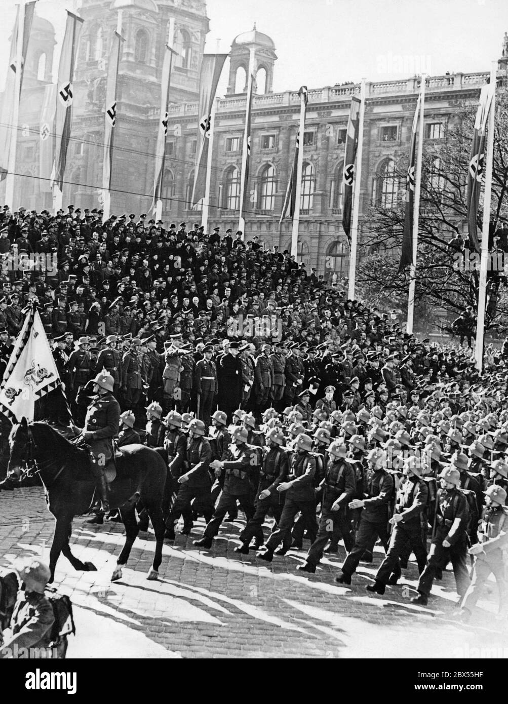 Die 8. Armee der Wehrmacht marschiert vor Adolf Hitler auf dem Heldenplatz in Wien, hier österreichische Soldaten. Dort kündigt Hitler die Annexion Österreichs an das Deutsche Reich an. Rechts von Adolf Hitler stehen die Generäle Fedor von Bock und Alfred Krauss (in Zivilkleidung). Stockfoto