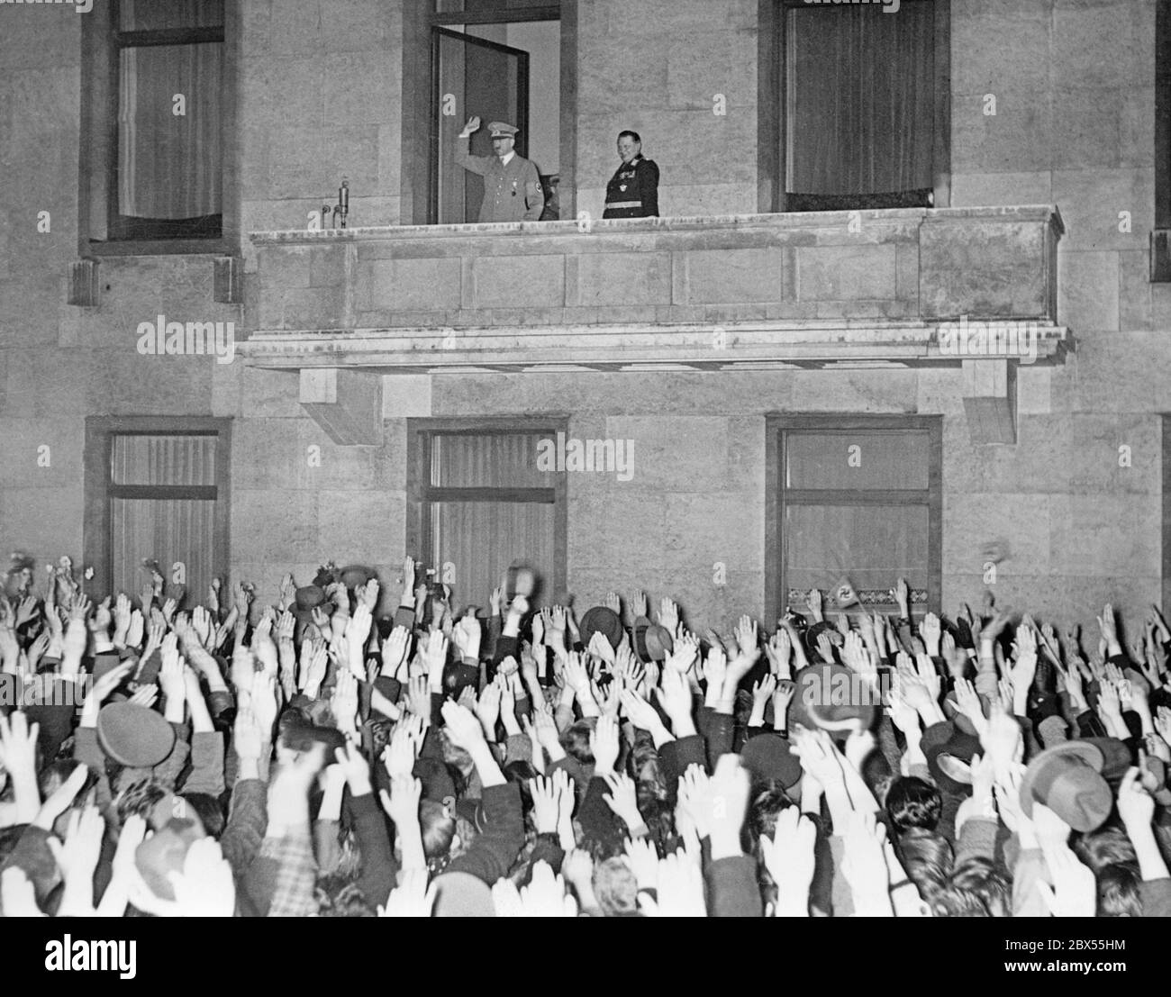 Adolf Hitler und Herman Göring auf dem Balkon der Reichskanzlei in Berlin. Nach der Annexion Österreichs an das Deutsche Reich kehrt Hitler nach Berlin zurück. Stockfoto
