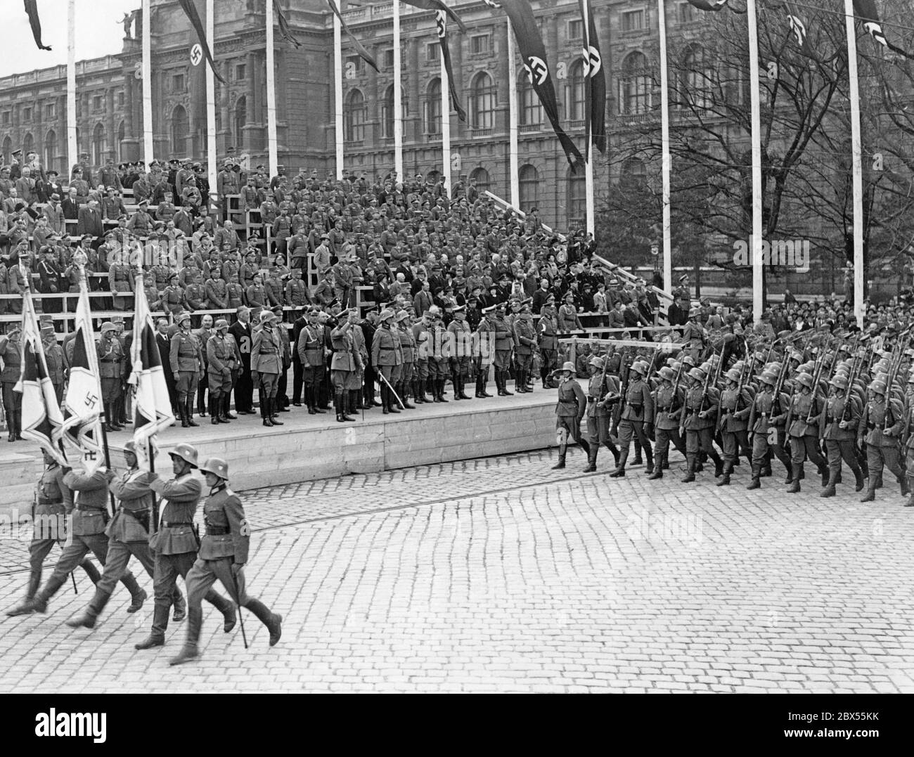 Die 10. Division der 8. Wehrmachtsarmee marschiert auf dem Heldenplatz vor der VIP-Tribüne. Die Parade findet im Rahmen der Kundgebung zur Annexion Österreichs an das Deutsche Reich statt. Neben Adolf Hitler nahmen auch Reichs-Gouverneur Arthur Seyss-Inquart und die Generäle Alfred Krauss und Fedor von Bock an den Feierlichkeiten Teil. Stockfoto