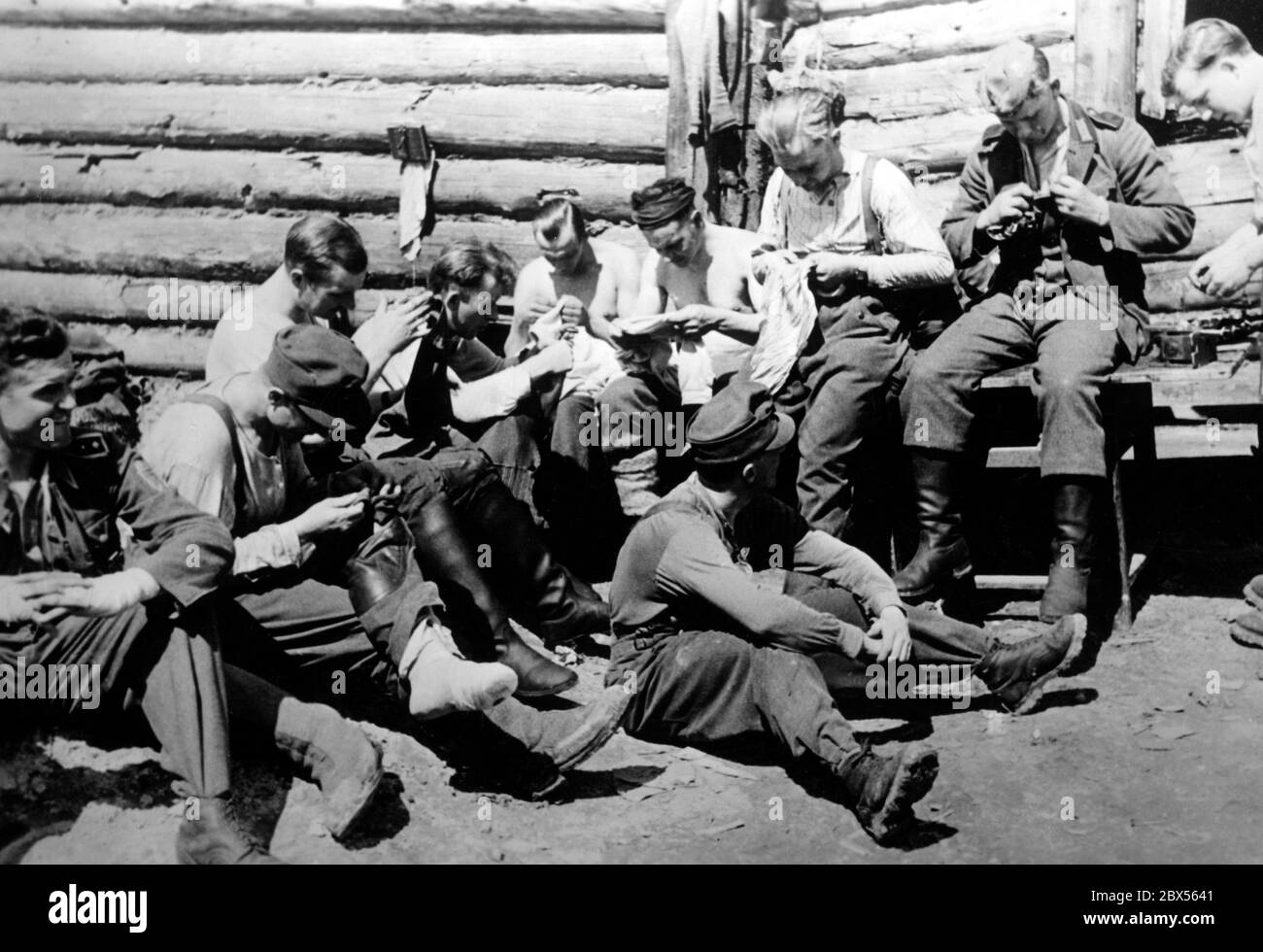 Bergtruppen des MG Bataillon 10, der mit etwa 200 Mann die Tasche brach und die in Kholm gefangenen Soldaten unterstützte, während er eine Pause in einer Holzhütte machte. Während der Einkreisungsschlacht von Kholm verteidigte die Kampfgruppe Scherer die Stadt erfolgreich für 105 Tage. (Ein Foto der Propaganda Company (PK) des Kriegsberichterstatters Richard Muck, der Anfang März in die Tasche flog). Stockfoto