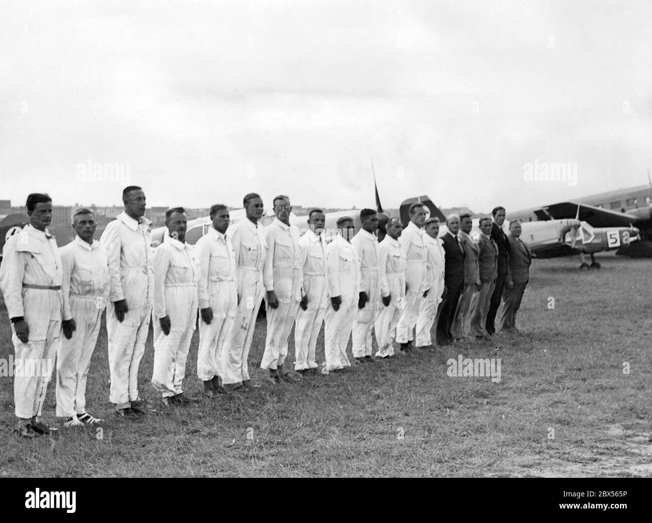 Deutsche Piloten nach ihrer Rückkehr aus Italien aufgereiht. Ihre Ebenen sind im Hintergrund. Stockfoto