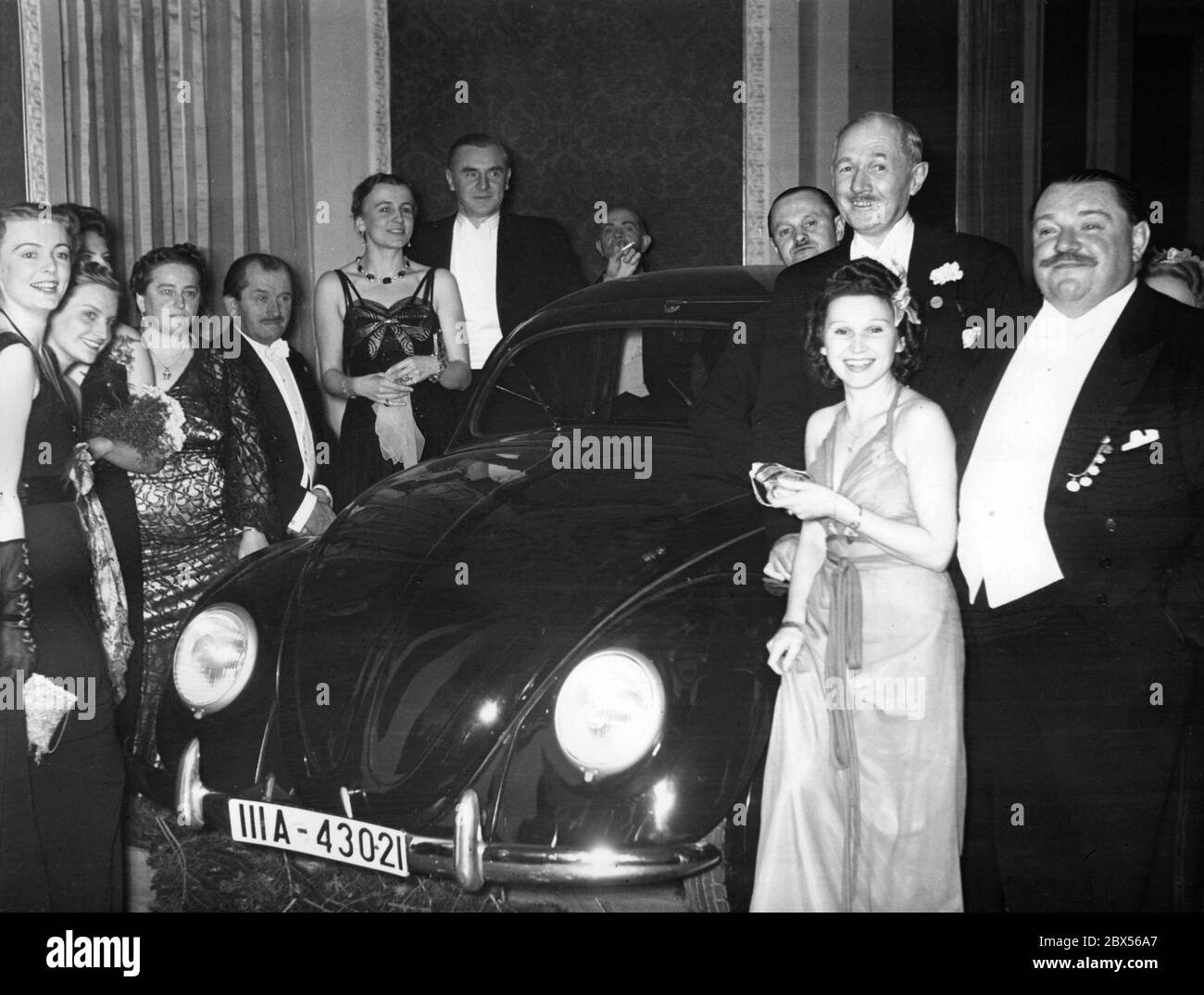 Hauptpreis der berühmten Verlosung des Pressebullen in Berlin 1939 ist Ferdinand Porsche's neuer Volkswagen (4. V.l.). Rechts der Naturwissenschaftler und Autor Bent Berg (2. Von rechts) und der Schauspieler Heinrich George (rechts). Stockfoto