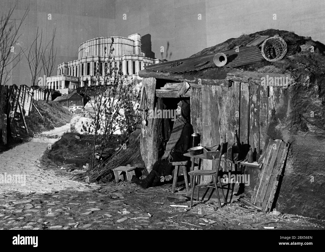 Blick auf die Ausstellung "das sowjetische Paradies" im Berliner Lustgarten: Ein Mann steht vor seiner armen Hütte. Daneben ist ein Bild einer Oper in Minsk, die die Kontraste propagandistisch symbolisieren soll. Stockfoto