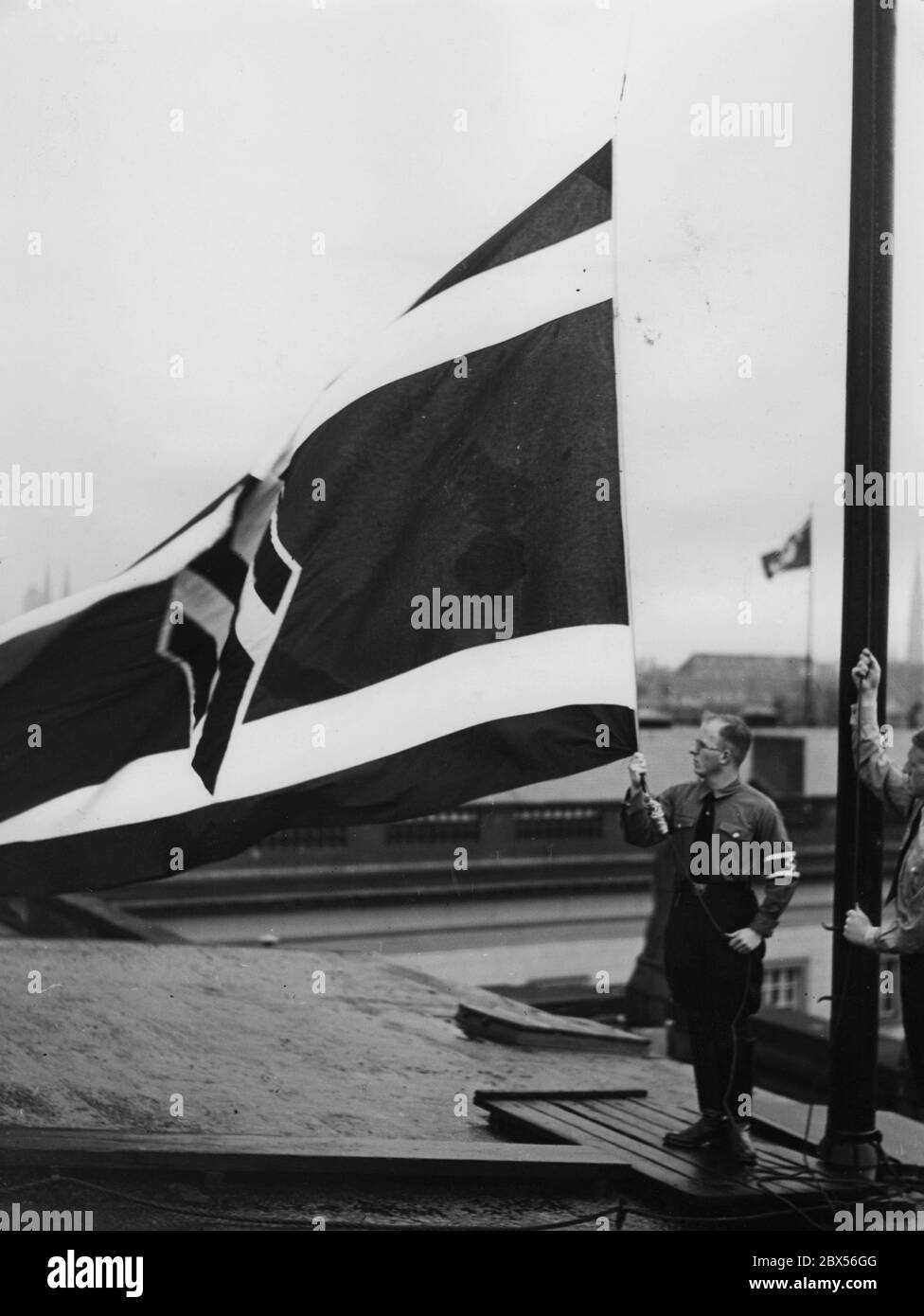 Erstmals erheben Studierende der NSDStB die Studentenflagge des nationalsozialistischen Deutschen Studentenbundes auf dem Gebäude der Friedrich-Wilhelms-Universität Berlin. Im Hintergrund die Spree. Stockfoto