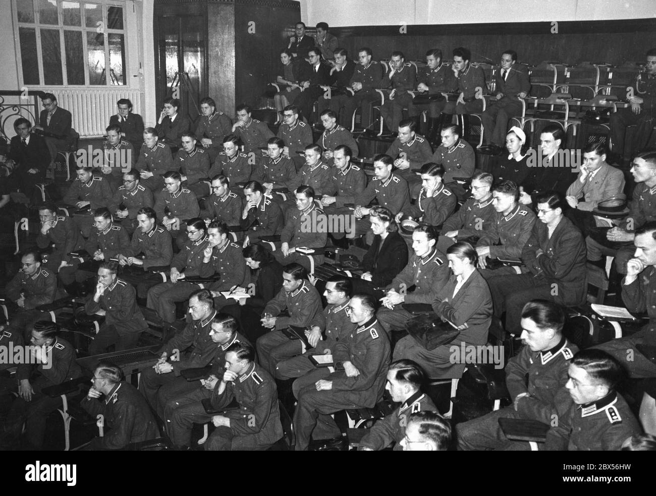 Nach der Eröffnung der Reichuniversität Straßburg am 23.11.1941 hält der Dekan der Medizinischen Fakultät Professor Dr. Stein (am Pult in Uniform) seinen ersten Vortrag. Im Bild das studentische Publikum in Uniform. Stockfoto