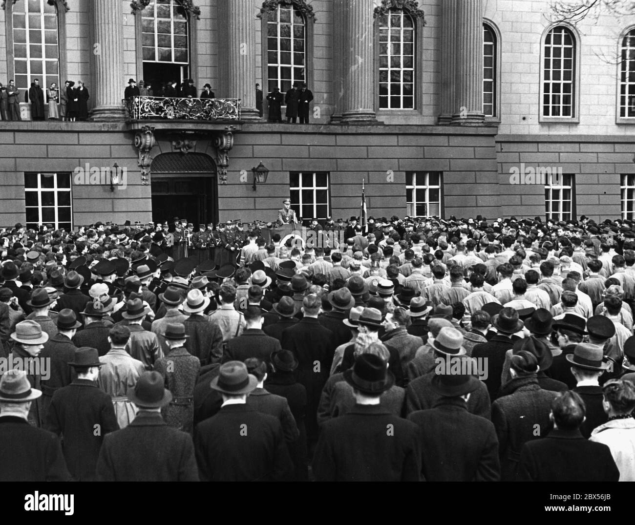 Die Flagge des nationalsozialistischen Deutschen Studentenbands wird erstmals auf dem Gebäude der Universität Berlin erhoben. Unter dem Balkon am Rednerpult befindet sich ein SS-Mann. Unter dem Balkon hält Rektor Professor Dr. Willy Hoppe eine Rede vor den versammelten Studenten. Stockfoto