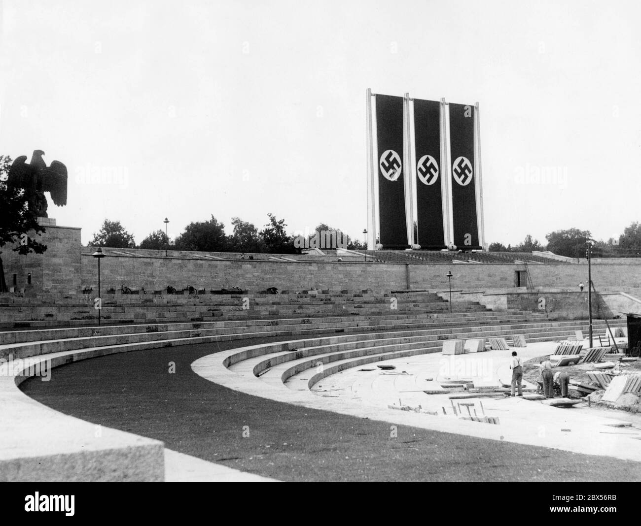 Während der Bauarbeiten in der Luitpoldarena wird für den Reichsparteitag eine Fahnenprobe mit drei Hakenkreuzfahnen durchgeführt. Links die souveränen Symbole: Kaiseradler mit Hakenkreuz. Stockfoto