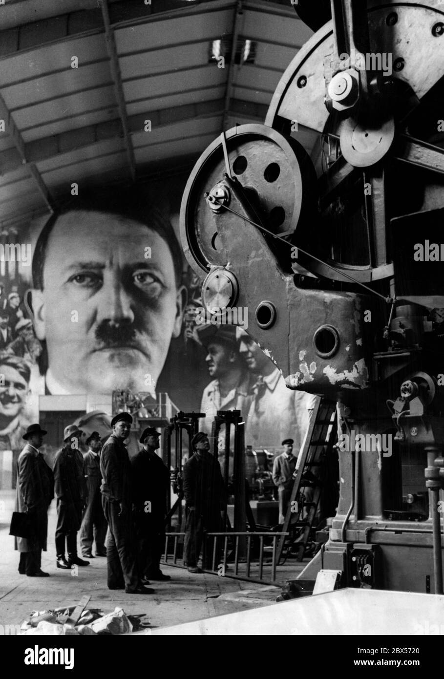 Mit der Ausstellung "Gebt mir vier Jahre Zeit" zeigt die Reichsregierung die Erfüllung der 1933 gemachten Versprechungen Adolf Hitlers (im Portrait) mit gigantischen Diagrammen und Exponaten. Stockfoto
