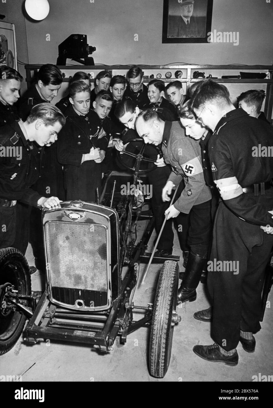 Ein NSKK-Mann erklärt einigen Mitgliedern der Motor HJ (Motorized Hitler Youth) den Lenkmechanismus eines Autos. Die Technik wird mit einem Hanomag 316 Auto erklärt. Stockfoto