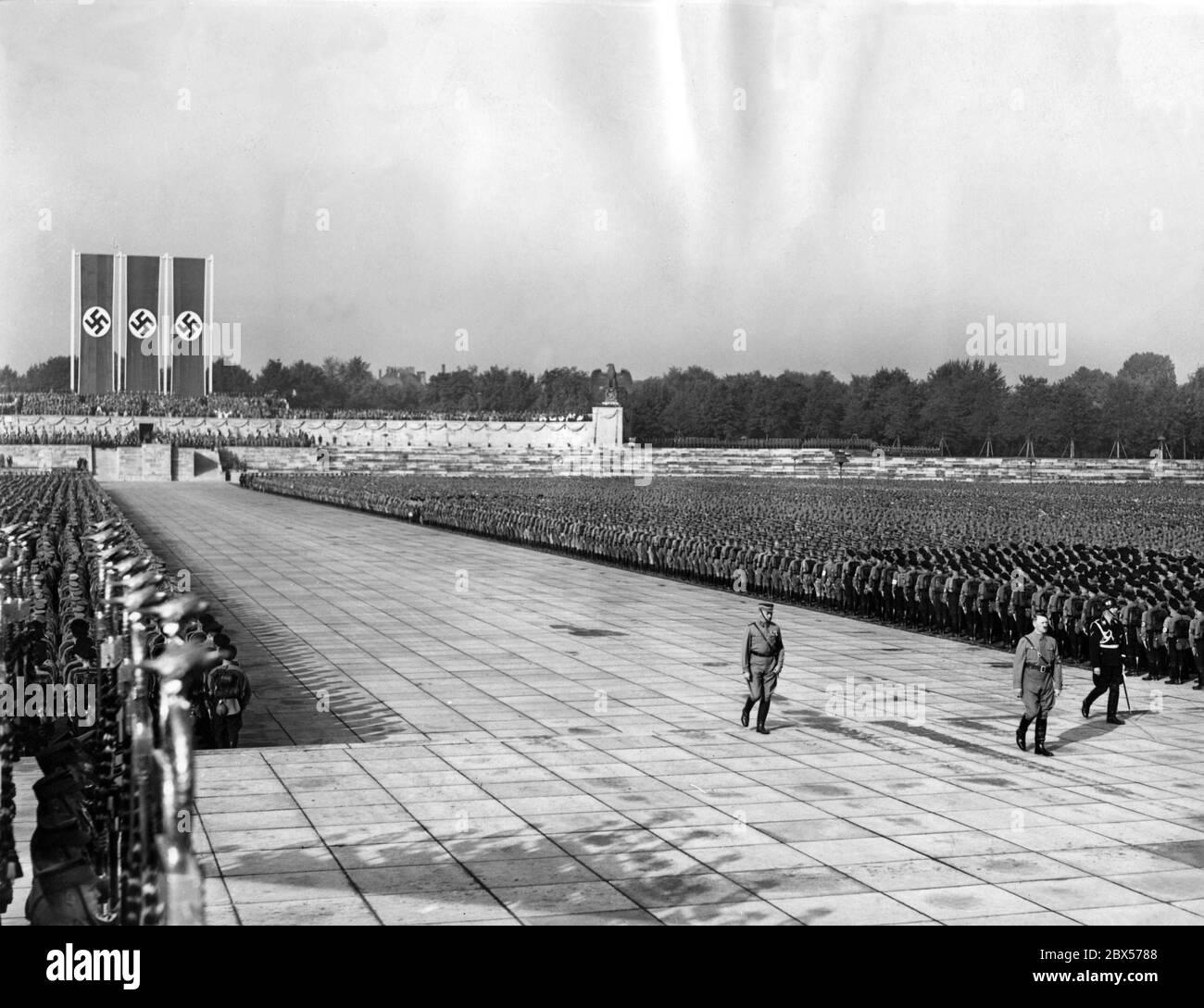 Adolf Hitler (vorne), Viktor Lutze (links) und Heinrich Himmler (rechts) marschieren durch die Ehrengarde der SA vom Trimm der Luitpold Arena zur Kranzniederlegung und Totengedenken in der Ehrenhalle. Stockfoto