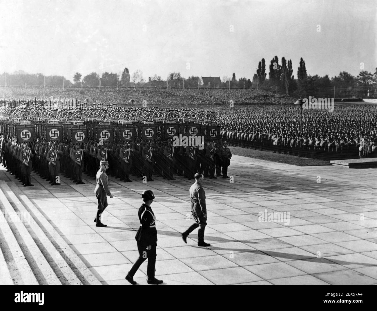 Adolf Hitler (vorne), Viktor Lutze (links) und Heinrich Himmler (rechts)marschieren am SA-Standard vorbei vom Podest der Luitpold-Arena zur Kranzniederlegung und Totengedenken in der Ehrenhalle. Stockfoto