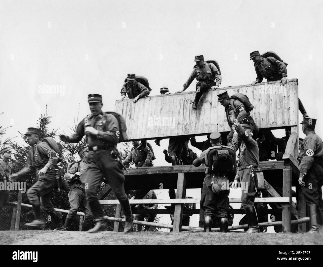 SA-Männer überwinden eine Hindernismauer, während des 25 Kilometer langen rudelmarsches bei den NS-Kampfspielen. Stockfoto