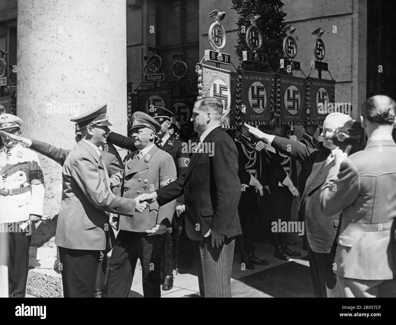 Adolf Hitler begrüßt August von Finck vor dem Haus der Deutschen Kunst (heute Haus der Kunst) in München. In der Mitte Gauleiter Adolf Wagner. Stockfoto