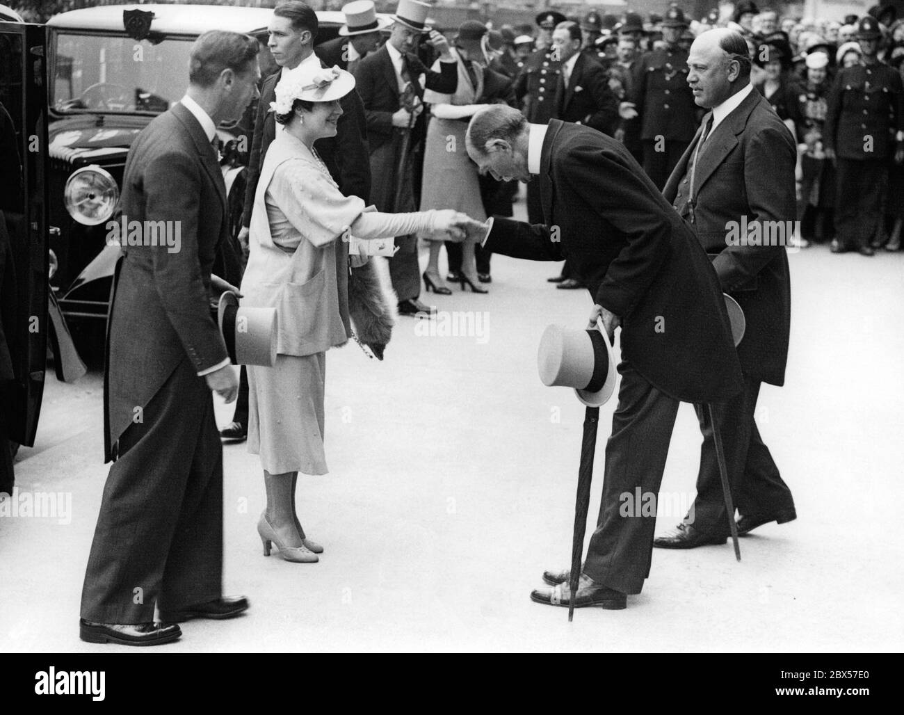 König Georg VI. Und Königin Elisabeth werden bei ihrer Ankunft am 'Ladies Day' in Epsom von Claude Bowes-Lyon, 14. Earl of Strathmore und Kinghorne und Vater der Königin, begrüßt. Stockfoto