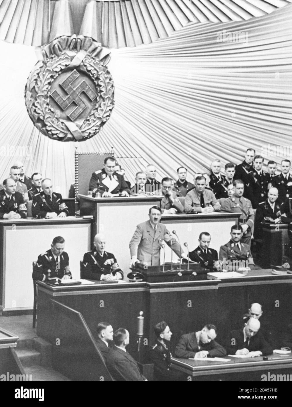 Adolf Hitler während seiner Rede bei einer Reichstagssitzung in der Berliner Kroll-Oper. Hinter ihm sitzt Hermann Göring am Schreibtisch des Reichstagspräsidenten. Stockfoto