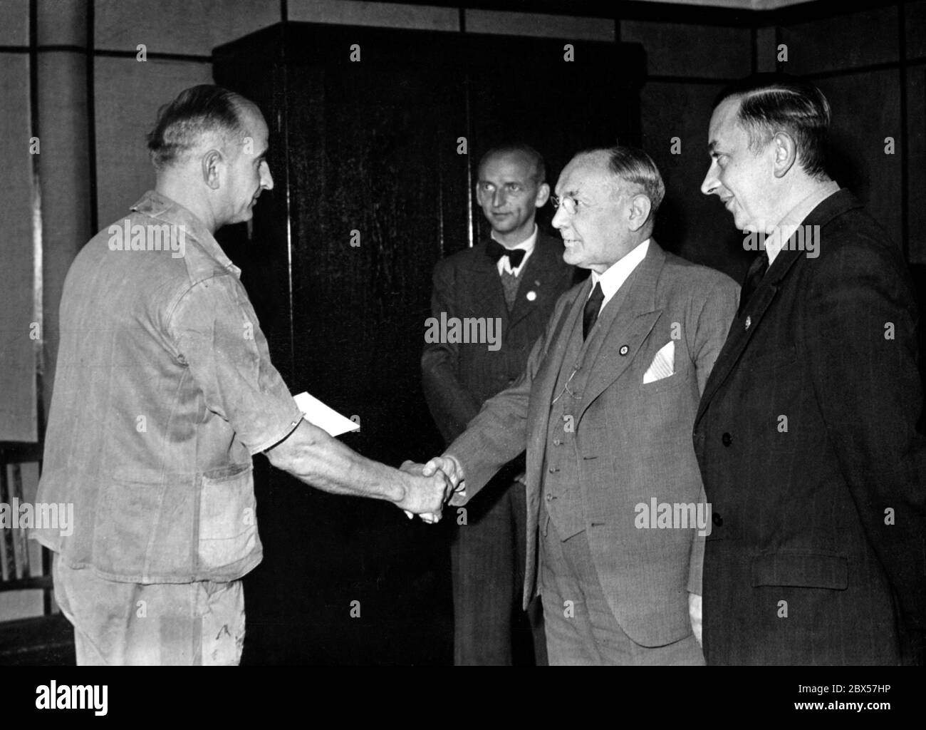 Der Schlosser Erich F. wird von der Unternehmensleitung für die Präsentation wertvoller Vorschläge zur Verbesserung des Betriebes gelobt. Er erhielt auch Geldzahlungen und Briefe der Anerkennung. Stockfoto