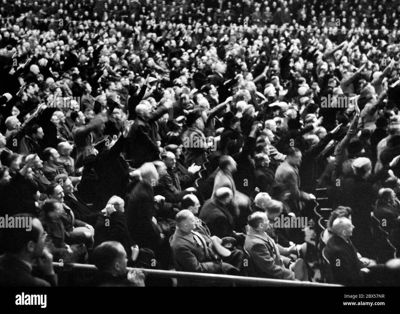 Nach der demagogischen Rede des Reichsministers für Propaganda Joseph Goebbels mit den berühmten Worten "Willst du totalen Krieg?", stehen einige der Anwesenden auf, um ihr Engagement mit dem Nazi-Gruß zu bekräftigen. Foto: Schwahn Stockfoto