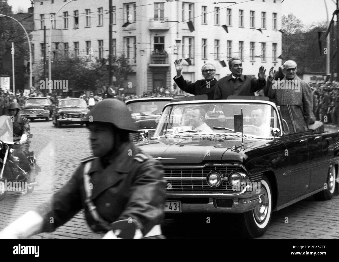Motorcade mit dem sowjetischen Parteichef Leonid Breschnew während eines Staatsbesuchs in Ost Berlin 1973 auf dem Weg zum Gästehaus der DDR-Regierung Schoenhausen Palast, von Erich Honecker und Willi Stoph, der Wellen begleitet die Menschen auf der Straße aus dem offenen Fahrzeug im Bezirk Pankow. Stockfoto