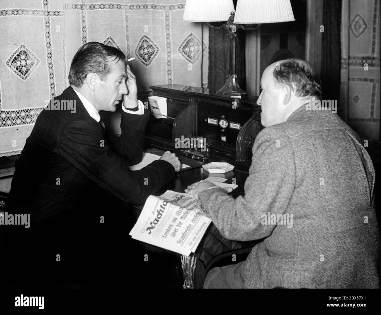 Ein Journalist der Zeitung 'Nachaugabe' interviewt den amerikanischen Schauspieler Gary Cooper (links) im Berliner Hotel Adlon. Stockfoto
