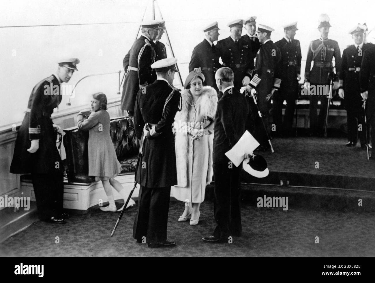 Elizabeth II. (Links), Queen Elizabeth und King George VI. (Rechts, hinter Queen) an Bord der königlichen Yacht 'Viktoria and Albert' während des großen Flottenreview mit englischen Heimatflotten und Kriegsschiffen anderer Nationen. Stockfoto