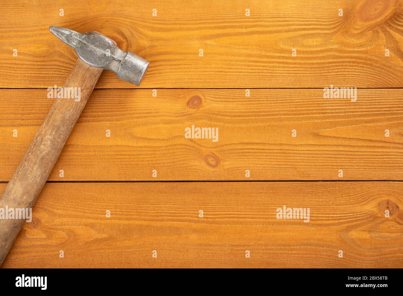 Eisenhammer mit Holzgriff auf Holzhintergrund, freier Platz für Text, Draufsicht Stockfoto