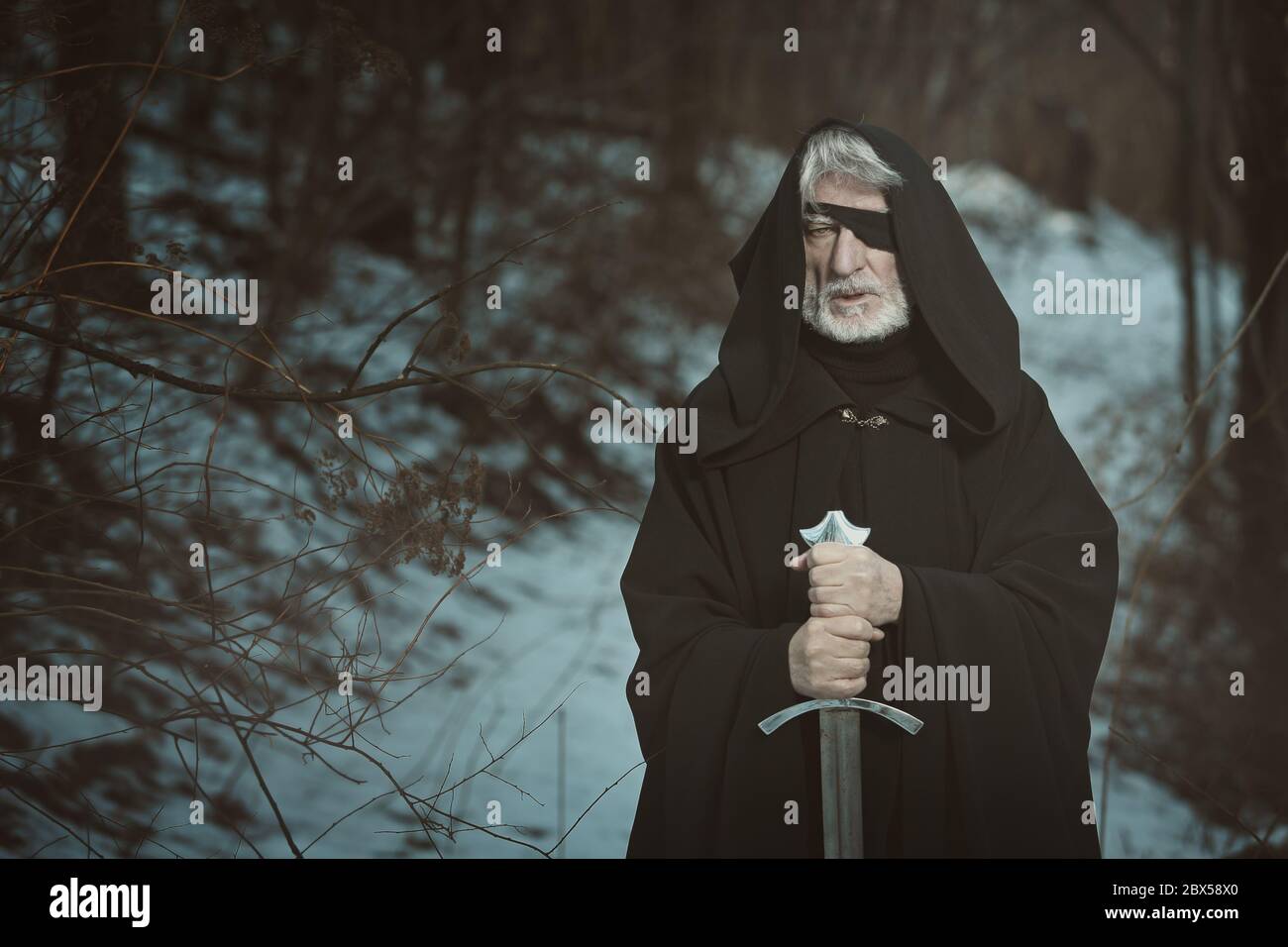 Alter ein Augen Mann mit Schwert in einem dunklen Wald. Fantasie und Mythologie Stockfoto