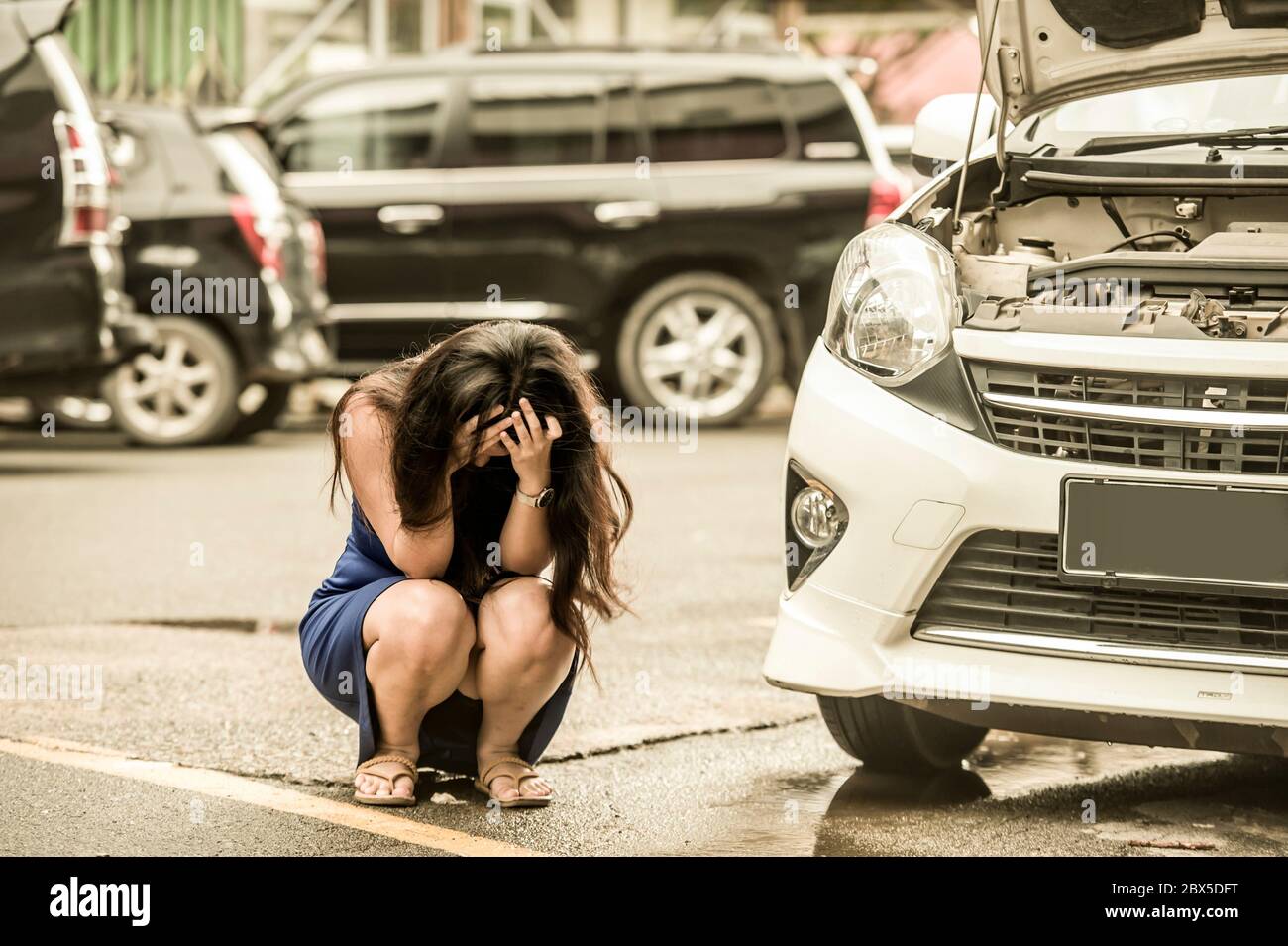 Junge verzweifelte und besorgte Frau im Stress gestrandet am Straßenrand mit Automotor Ausfall mit Mechaniker Problem Reparatur-Service und Hilfe benötigen Stockfoto