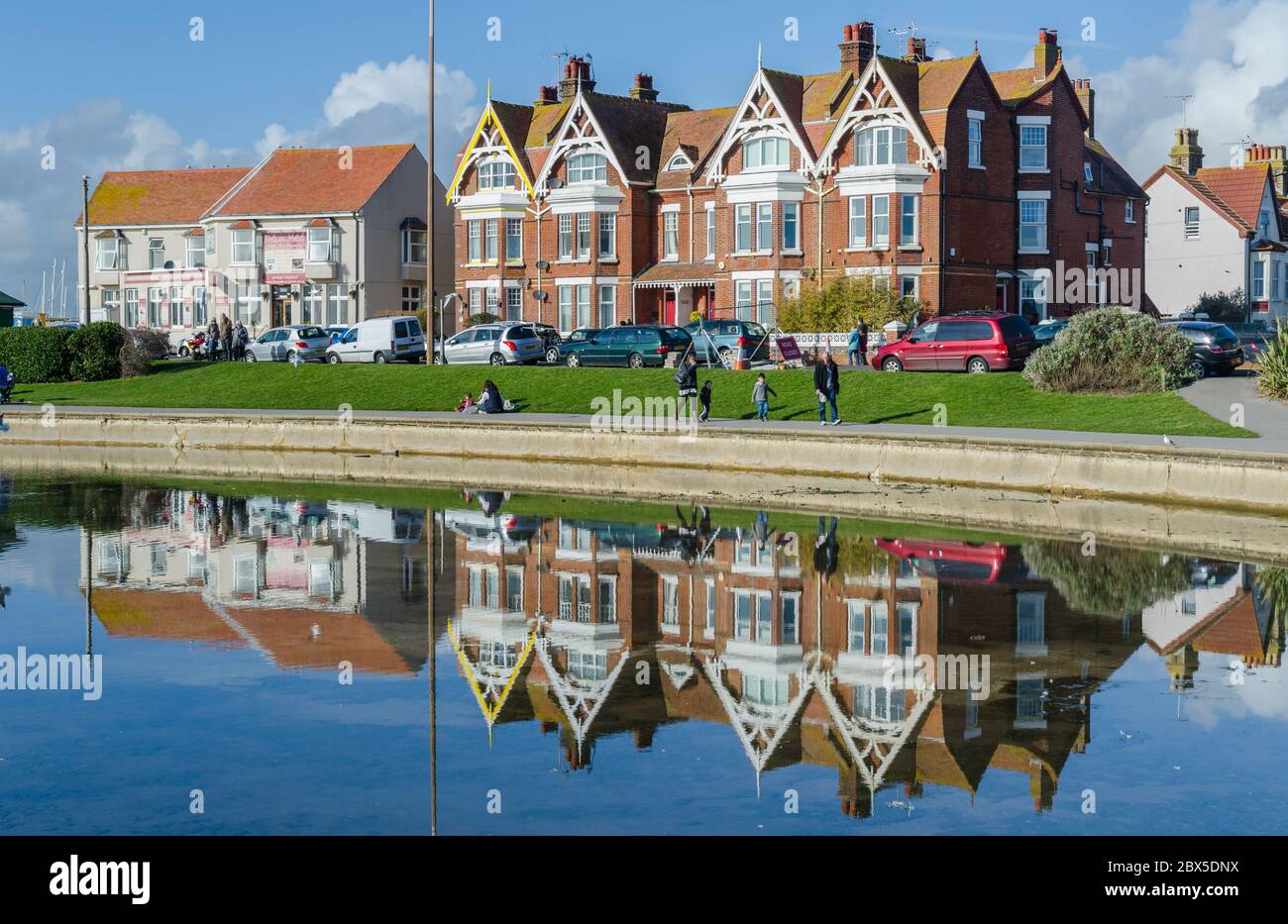 Viktorianisches Haus mit Spiegelungen in einem nahe gelegenen See am Oyster Pond in Littlehampton, West Sussex, England, Großbritannien. Stockfoto