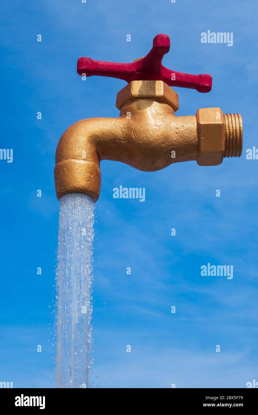 Brunnen, gegen den blauen Himmel, stilisiert wie ein Wasserhahn mit fließendem Wasser. Das Konzept der globalen Sauberkeit und Hygiene. Kopierraum Stockfoto
