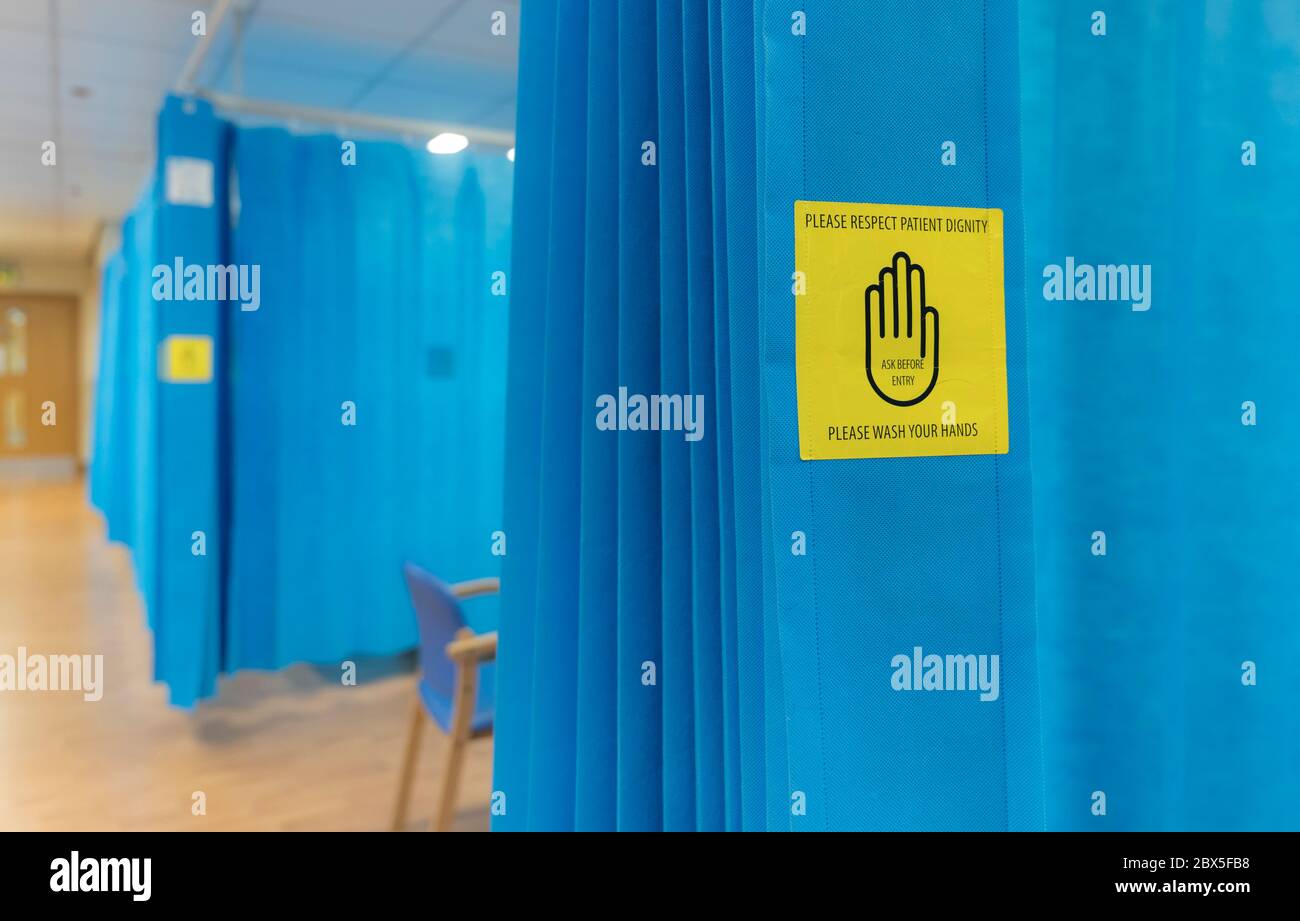 Auf einer Krankenhausabteilung in Großbritannien einen Vorhang um ein Bett herum anbringen. Stockfoto