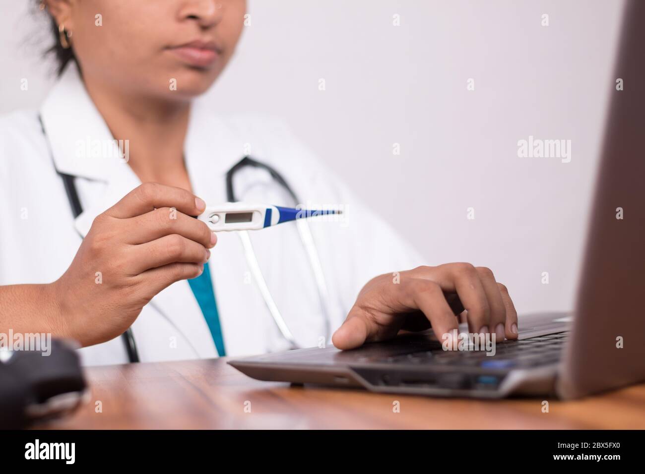 Arzt erklärt, wie man Fieberthermometer zum Patienten durch online auf Laptop - Konzept der telemedizinischen oder Telemedizin mit Patienten während verwenden Stockfoto