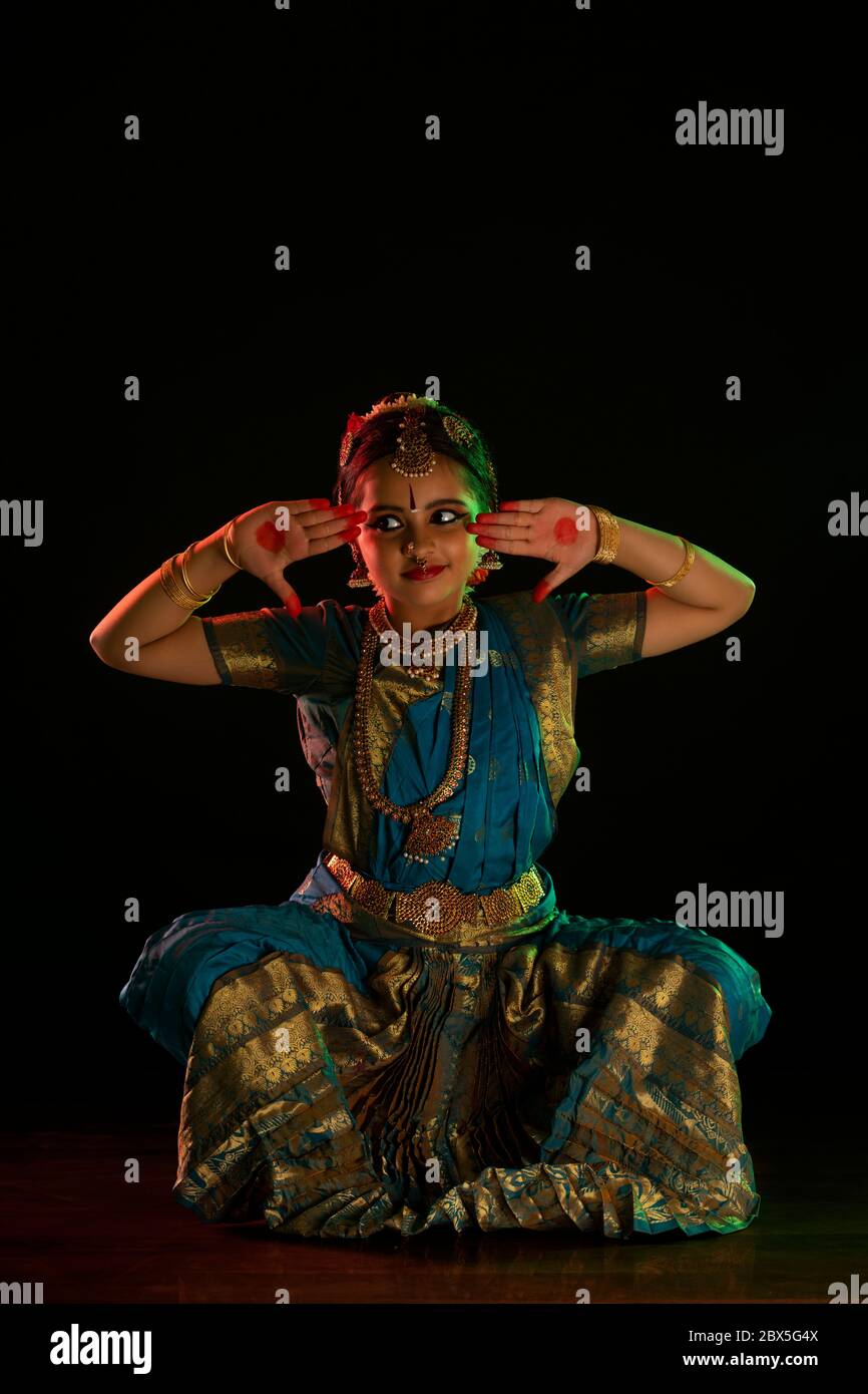 Junge Bharatnatyam-Tänzerin, die während einer Aufführung ein ardha chandra-Mudra macht. Stockfoto