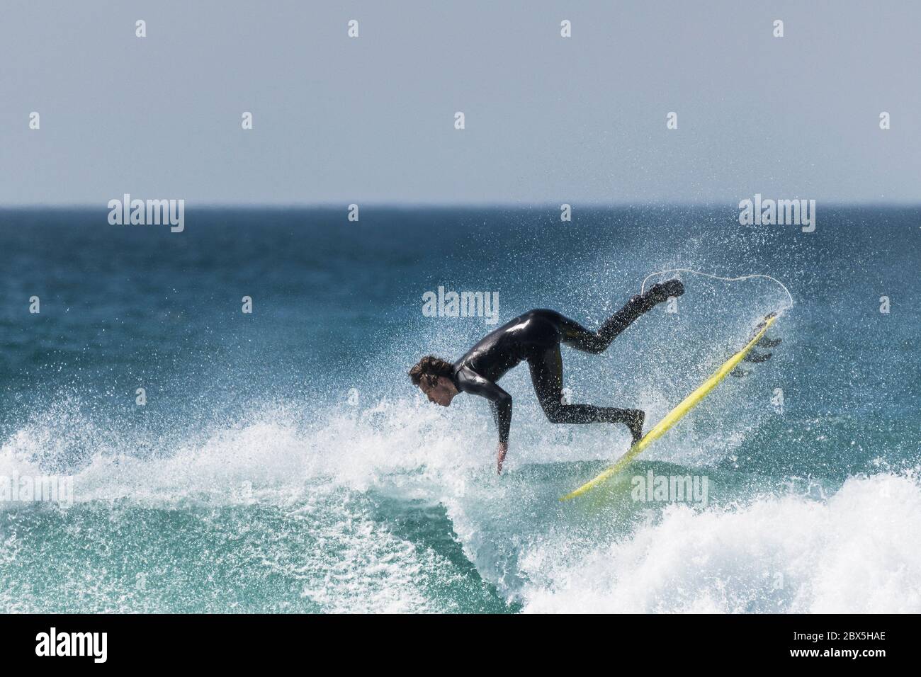 Spektakuläre Action, während ein junger Surfer im Fistral in Newquay in Cornwall auftauchte. Stockfoto