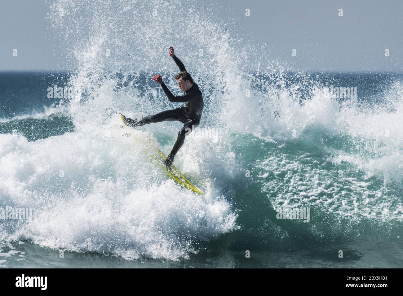 Spektakuläre Action, während ein Surfer eine Welle in Fistral in Newquay in Cornwall reitet. Stockfoto