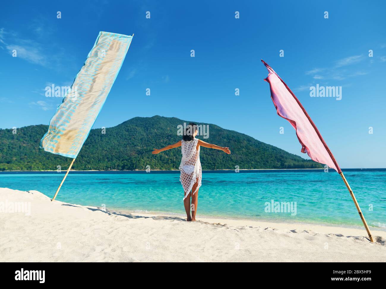 Junge Frau mit Händen nach oben entspannen und genießen türkisfarbenes Meer am tropischen Strand in Paradise Island. Reise, Urlaub, Rest Konzept Stockfoto