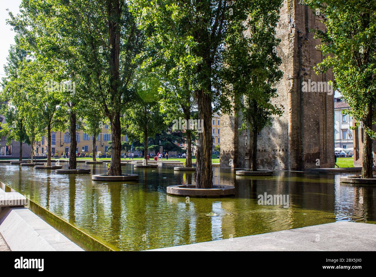 Parma, Italien - 8. Juli 2017: Blick auf einen Brunnen mit Bäumen auf der Piazzale della Pace an einem sonnigen Tag Stockfoto