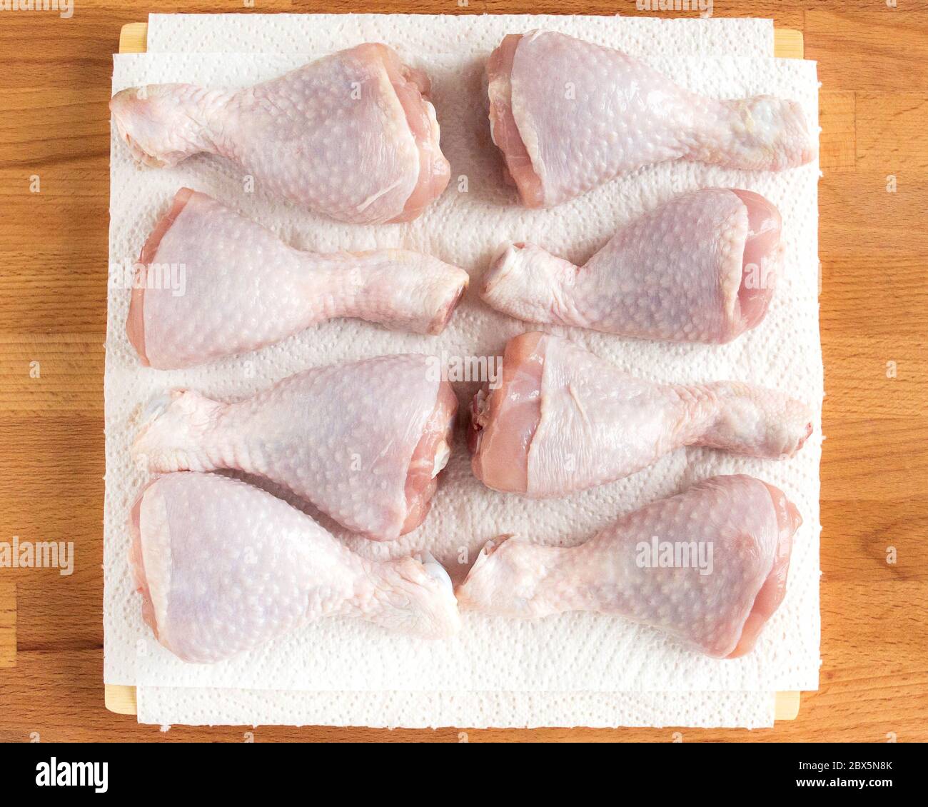Hühnertrommelstab liegt auf Küchentücher. Hähnchen zum Braten vorbereiten. Stockfoto