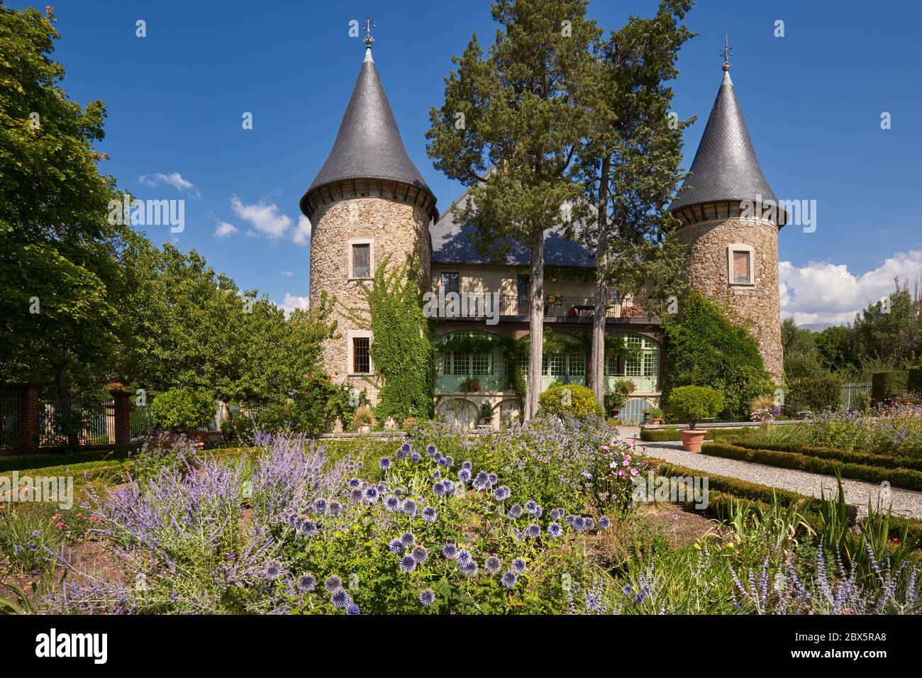 Les Crots, Hautes-Alpes, Frankreich: Schloss Picomtal (historisches Denkmal) mit seinen zwei Türmen und Sommergarten in Blüte. Region Provence-Alpes-Cote d'Azur Stockfoto