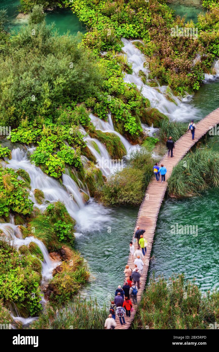 Nationalpark Plitvicer Seen in Kroatien, Menschen, Gruppe von Touristen auf Holzweg über den See mit zahlreichen Wasserfällen, Wasserfälle, Luftwie Stockfoto