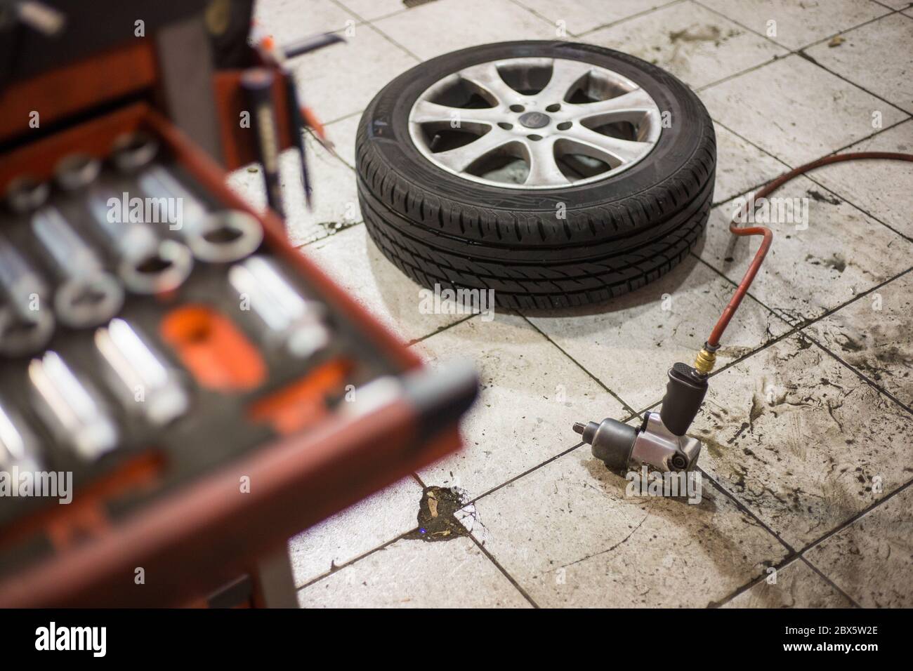 Vakuumpistole zum Austausch Räder des Autos auf dem Boden, Transport-Konzept, Auto-Service-Center Stockfoto