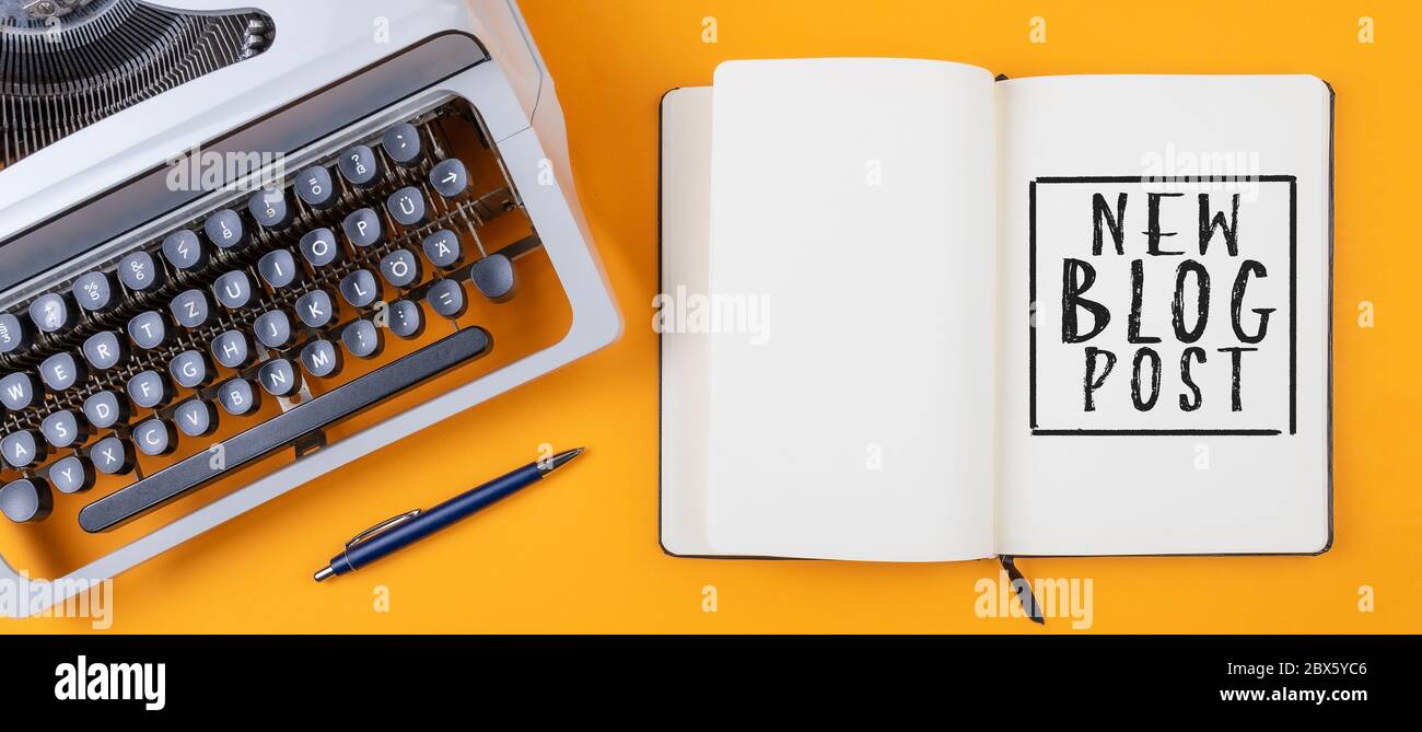 Oben Ansicht alte Schreibmaschine und Tagebuch mit Text NEUER BLOG-BEITRAG auf orangefarbenem Schreibtisch, Blogging-Konzept Stockfoto