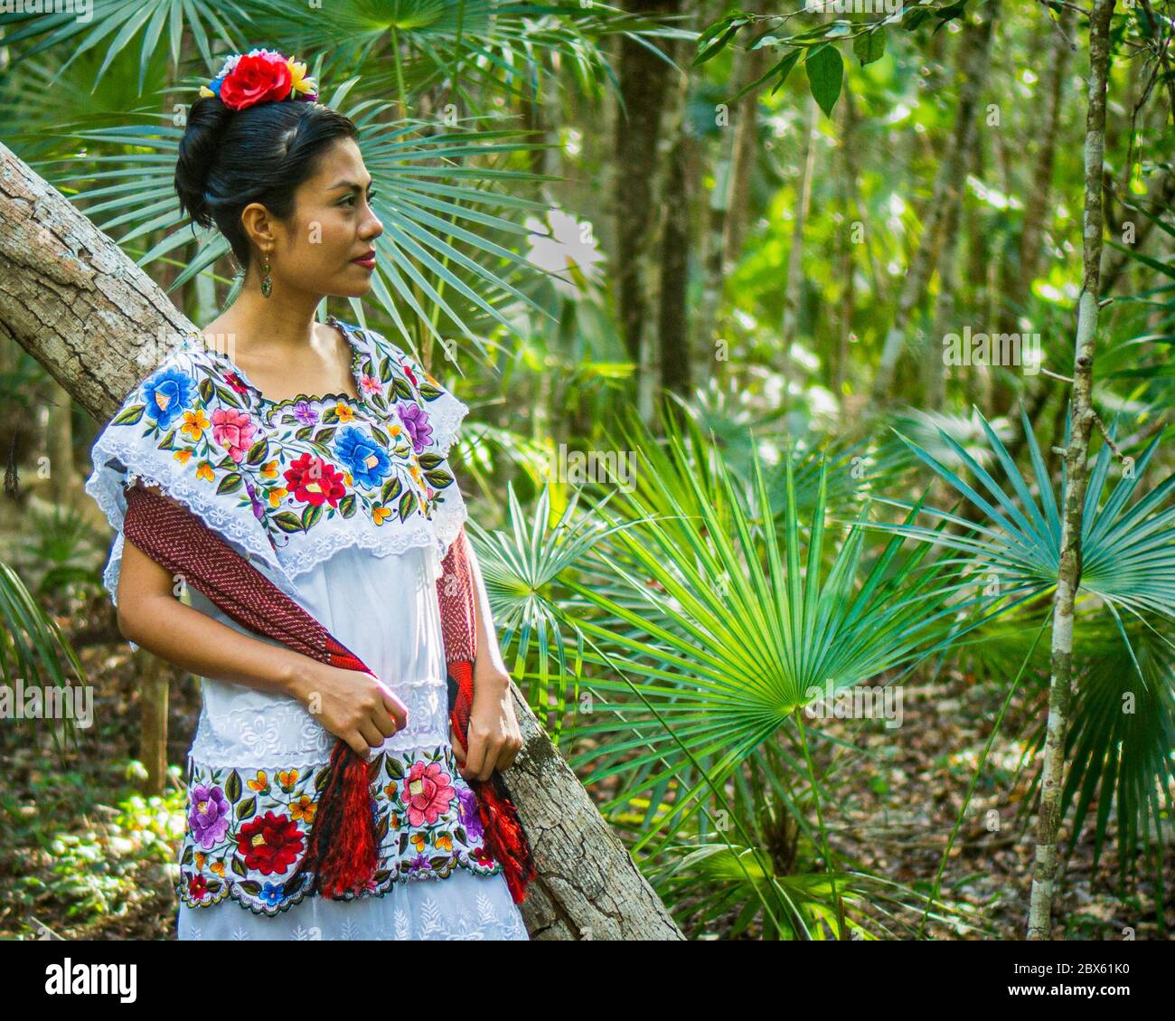 Tulum, Quintana Roo, Mexiko- Februar 24,2020: Eine schöne mexikanische Frau wartet im Dschungel in ihrem Huipil-Kleid, einer traditionellen Yucatán-Tracht Stockfoto