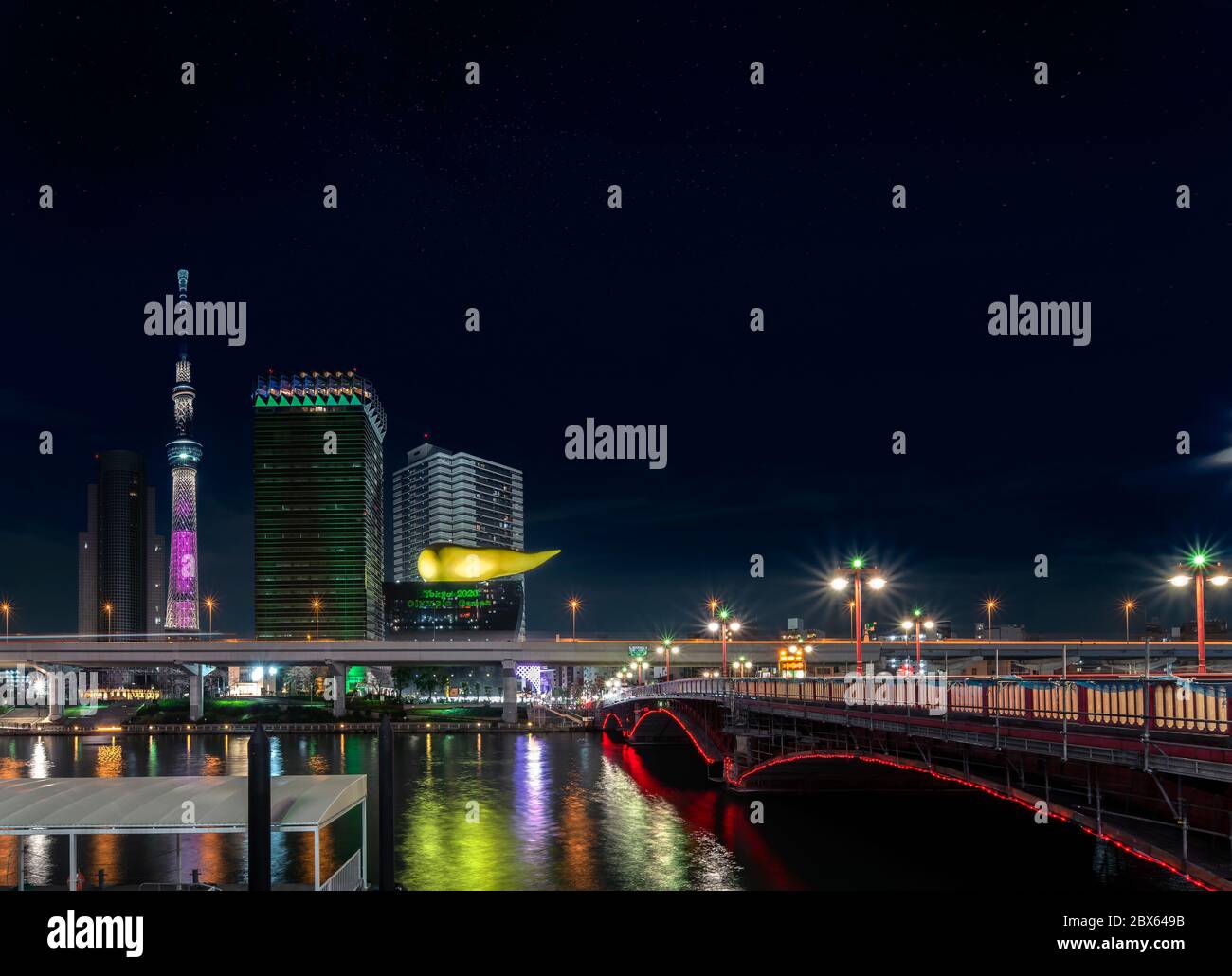 tokio, japan - märz 25 2020: Nachtansicht der Azuma-Brücke am Sumida-Fluss und der goldenen flammenförmigen Skulptur des Asahi Beer Headquarter wo sind Stockfoto