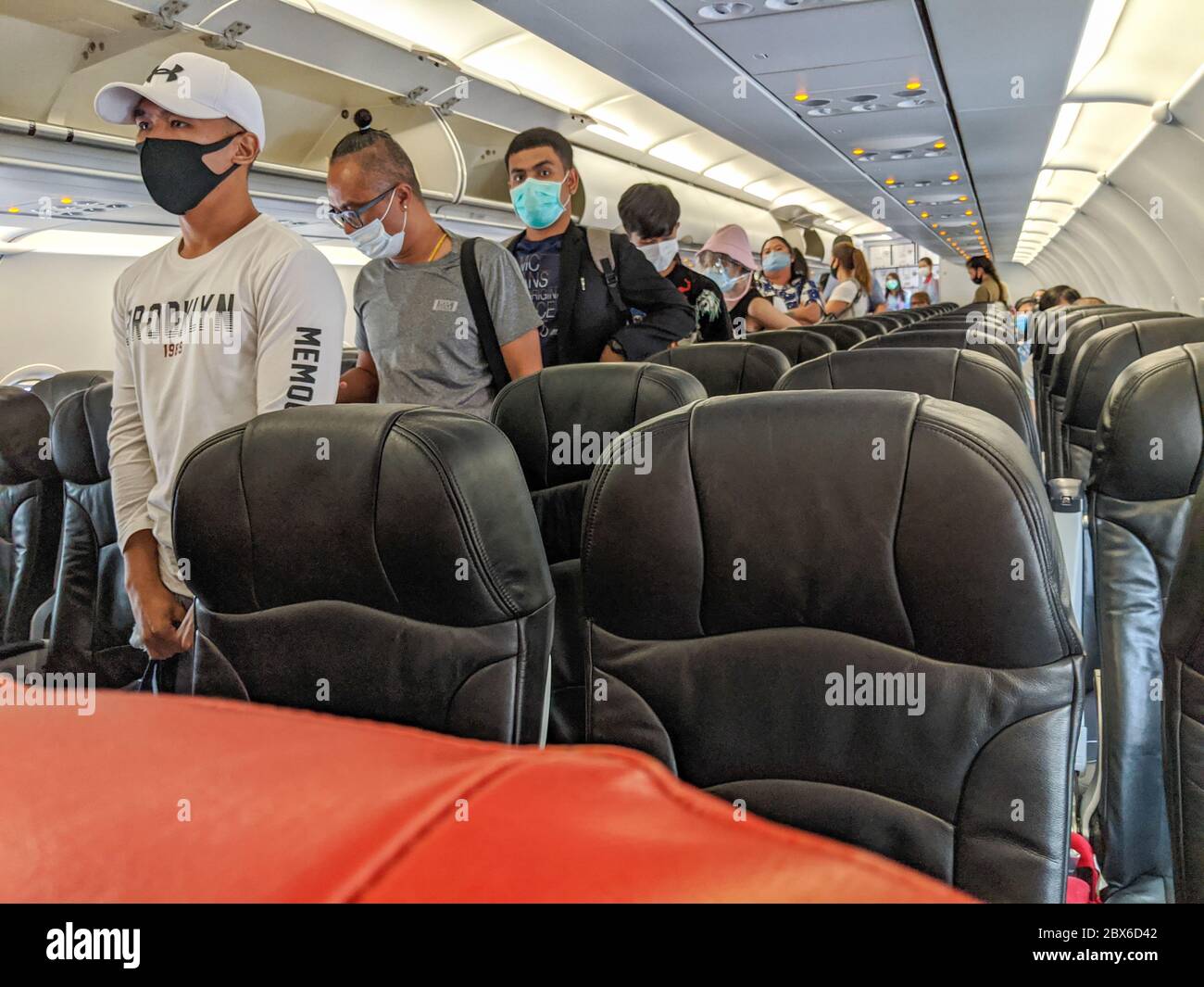 Maskierte Passagiere warten auf einen Inlandsflug von Air Asia nach Bangkok. Thailand hat die Inlandsflüge wieder aufgenommen Stockfoto